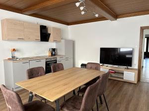 une cuisine et une salle à manger avec une table et des chaises en bois dans l'établissement Golf und Thermen Ferienhaus Golfblick Bad Loipersdorf, à Gillersdorf