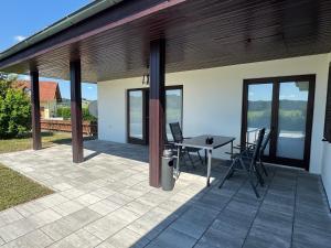 un patio avec une table et des chaises dessus dans l'établissement Golf und Thermen Ferienhaus Golfblick Bad Loipersdorf, à Gillersdorf