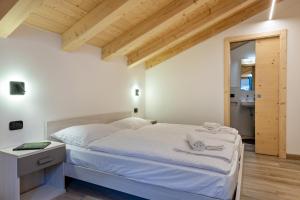 a bedroom with a bed with white sheets and towels at Tobià de Pit in Soraga