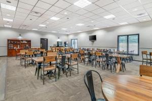 a dining room with tables and chairs and a flat screen tv at The Green Granite North Conway, an Ascend Collection Hotel in North Conway