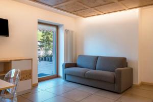 a living room with a couch and a sliding glass door at Buffaure a parte in Pozza di Fassa