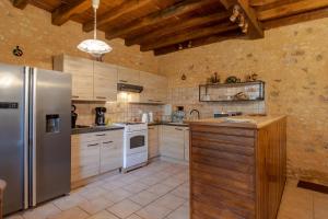 una cucina con frigorifero in acciaio inox e fornello di Logement Les Termes a Paunat