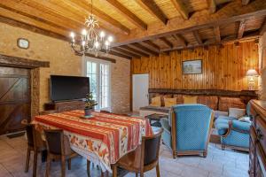 una sala da pranzo con un tavolo e una tv di Logement Les Termes a Paunat