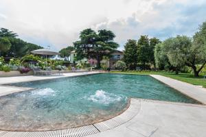 a swimming pool with a fountain in the middle at Abaye I Champagne Charm Adults Only in Soiano del Lago