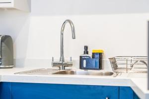 a kitchen counter with a sink and blue cabinets at Modern 2 Bedroom Apt in City Centre Free Parking with Fast WiFi Near Arena in Nottingham