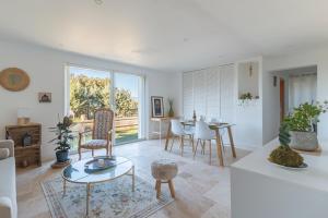 een witte woonkamer met een tafel en stoelen bij La Bastidonne in La Bastidonne