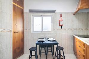 eine kleine Küche mit einem blauen Tisch und Stühlen in der Unterkunft Casa da Vila nº4 in São Brás de Alportel + 17 Fotos