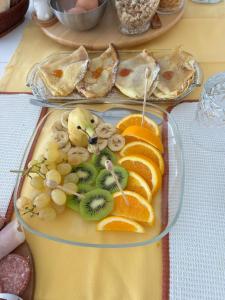 a plate of food with fruit on a table at B&B Grace in Villa Opicina