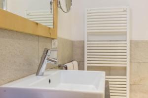 Un baño con un lavabo blanco y un espejo. en Superior Apartments Marialisa Rose, en Chiusa 37 fotos más