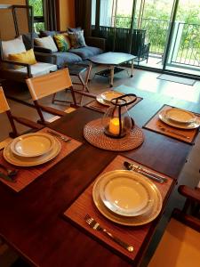 a living room with a table with plates and utensils at The Valley Escape สองห้องนอน สวย สงบ สบาย in Phayayen