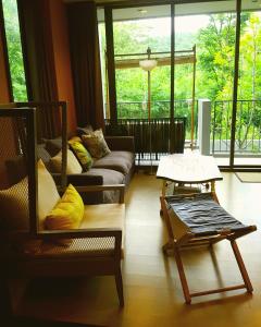 a living room with a couch and a table at The Valley Escape สองห้องนอน สวย สงบ สบาย in Phayayen