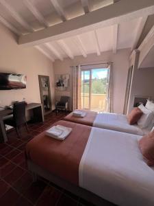 アラゴンにあるLogis Hôtel Restaurant La Bergerieのベッド2台と机と窓があるホテルの部屋