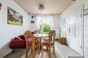 ノルトシュトラントにあるAuszeit Il am Deich auf Nordstrandのテーブルと椅子と窓のあるダイニングルーム +15枚の写真