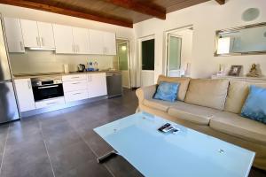 ein Wohnzimmer mit Couch und Küche in der Unterkunft Finca House By Fataga Maspalomas in Artedara