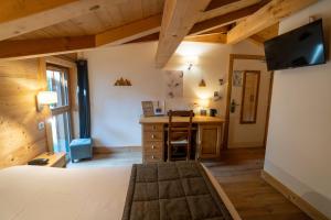 a bedroom with a bed and a desk in a room at La Ferme Du Lac in Thyez