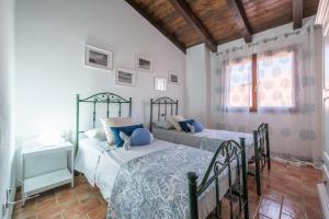 Un dormitorio con dos camas y una mesa y ventanas. en Villa Rossu, en Nuxis