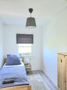 a bedroom with a bed with a blue comforter and a window at Schönes Apartment In Walschleben in Walschleben
