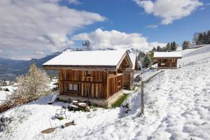 Una cabaña de troncos con nieve en una colina nevada en Mazot des aravis, en Combloux