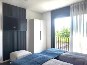 a bedroom with a bed and a large window at Ferienhaus Schlossterrassen 8b in Pouch