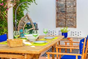 a wooden table with plates and wine glasses on it at Aloes in Sa Caleta