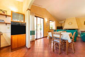 una cucina e una sala da pranzo con tavolo e sedie di Casa Mameli a Quartucciu