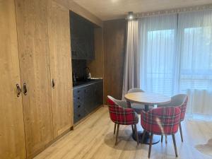 a dining room with a table and chairs and a window at Apartmán Forest, Tatranská Štrba in Tatranska Strba
