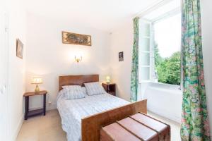 un dormitorio con una cama y una ventana en La Serre, en Laborde