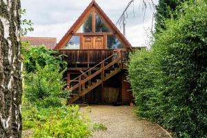 a log cabin with a large glass door and a wooden porch at Wohlfühlurlaub in der Scheune in Ochsensaal