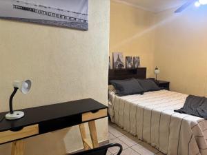 a bedroom with two beds and a desk with a lamp at Plaza Godoy Cruz, habitacion y baño privado en casa 6 ambientes terraza parrilla in Godoy Cruz