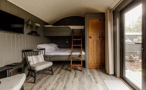 a small room with a bunk bed and a ladder at Shepherds Huts at Ballyness Farm in Dungiven