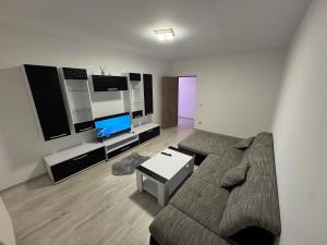 a living room with a couch and a flat screen tv at Staywell family apartment in Suceava