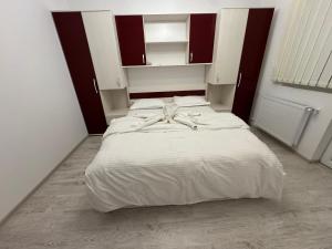 a bedroom with two beds with white sheets and a bow at Staywell family apartment in Suceava