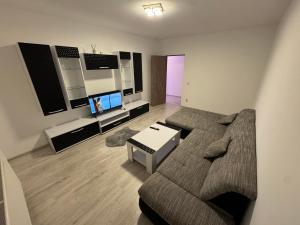 a living room with a couch and a tv at Staywell family apartment in Suceava