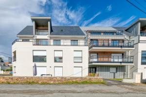 a white house with a gray roof at Appartement Port Lin proche Océan in Le Croisic