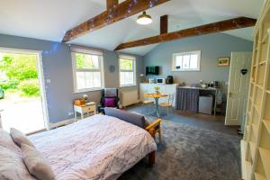 a bedroom with a large bed and a kitchen at The Den - Winchelsea in Winchelsea