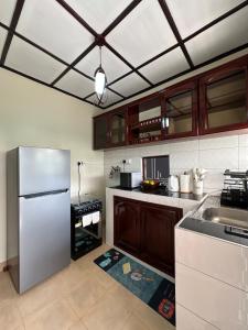 a kitchen with a stainless steel refrigerator and cabinets at The K Residence in Kampala
