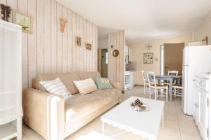 een woonkamer met een bank en een tafel bij Maison N°3 - Résidence Pingettes in Le Bois-Plage-en-Ré