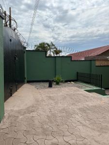a building with a green wall and a patio at The K Residence in Kampala