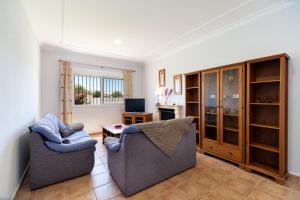 a living room with two chairs and a television at Chalet Isla del Sotillo in Chiclana de la Frontera