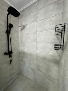 a bathroom with a shower with a tile wall at Хостел "Батискаф" in Bila Tserkva +39 photos