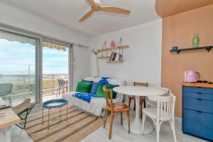 a living room with a bed and a table and chairs at Appartement front de mer - Terrasse in Pornichet