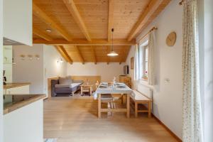 eine Küche und ein Wohnzimmer mit Tisch und Stühlen in der Unterkunft Klamperhaus-Hof in St. Johann im Ahrntal + 21 Fotos