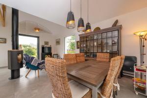 a dining room with a wooden table and chairs at Maison bord de mer in Sarzeau
