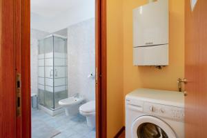 a bathroom with a washing machine and a toilet at Residence Appartamento Roma in Civate