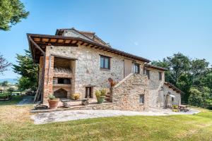 Vista exterior de una casa de piedra con horno. en Girasole - Agriturismo Fogliani, en Giano dellʼUmbria