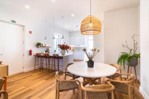 a kitchen and dining room with a table and chairs at Solar do Ilheuzinho in Câmara de Lobos