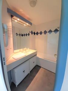 a bathroom with a sink and a mirror and a tub at Le Cabano'scope in Jaunay-Marigny