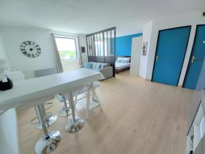 a kitchen and living room with a table and chairs at Le Cabano'scope in Jaunay-Marigny