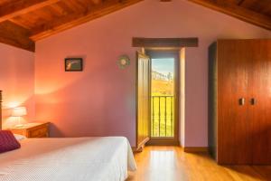 ein Schlafzimmer mit einem Bett und einer Tür mit einem Fenster in der Unterkunft Casa Alba in Bárcena de Cicero