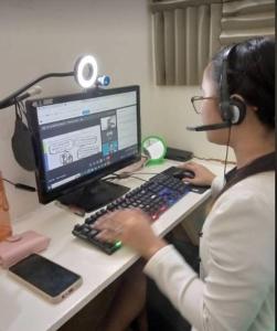 Una mujer con auriculares está usando una computadora con auriculares. en Uplink Services, en Marilao